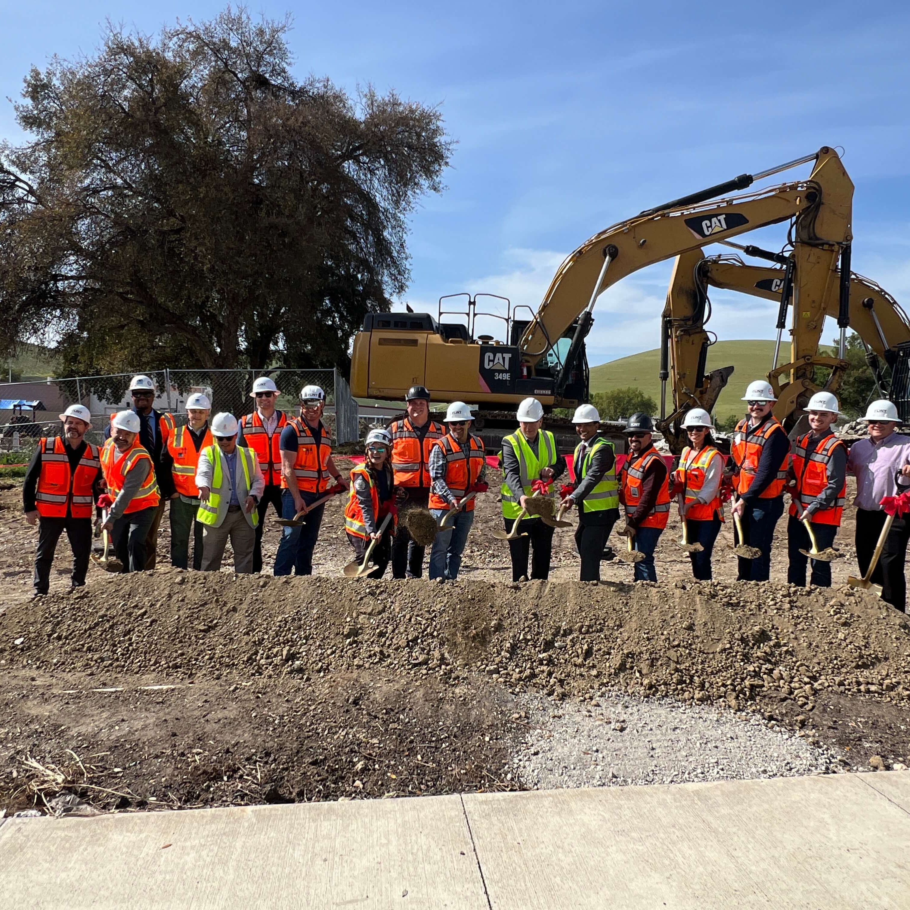 Group at groundbreaking with tractor in the background
