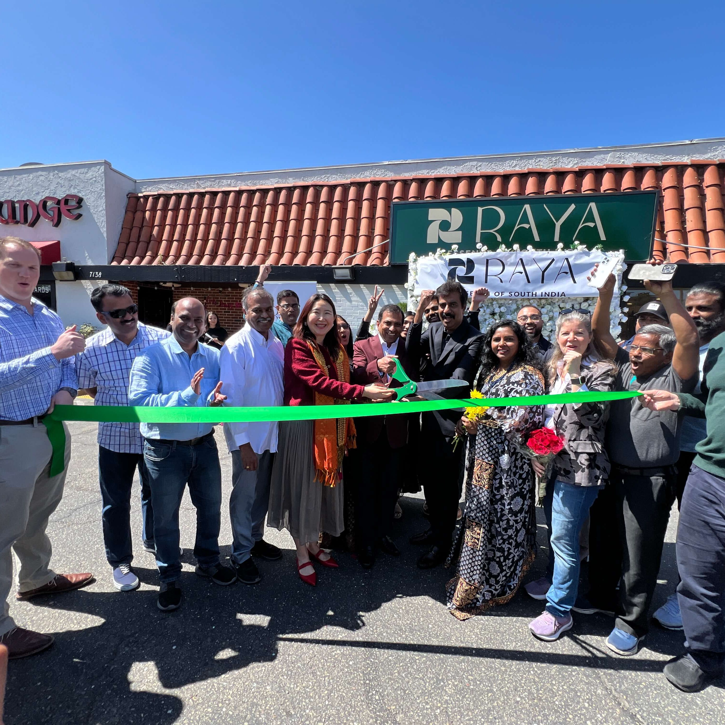 Group of people in front of Raya restaurant for a ribbon cutting