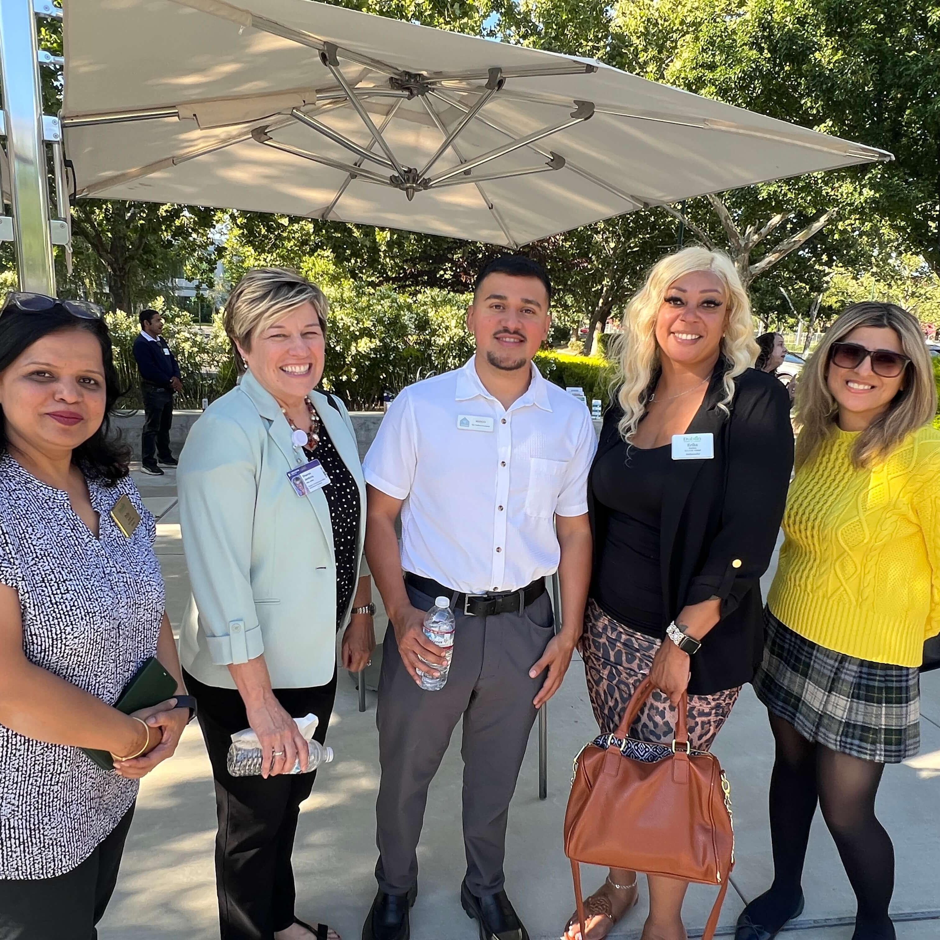 Group standing under an umbrella outside